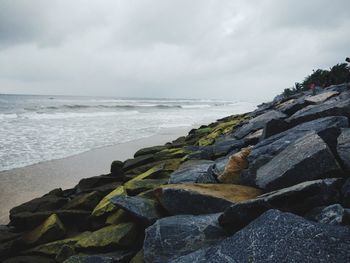 Rocks by sea against sky