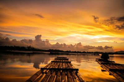 Pier over lake against sky during sunset