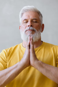 Mature man meditating at home