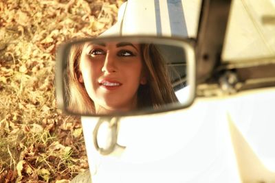 Woman face seen through mirror of car