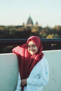 Portrait of woman standing against water
