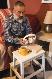 Side view of man sitting at home