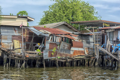 Houses by river against sky