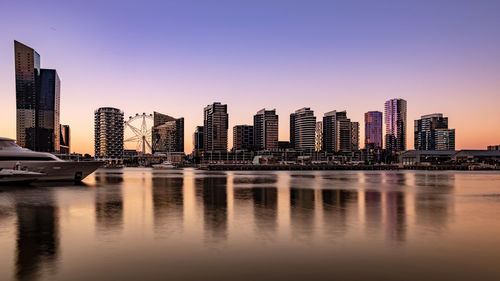 Modern buildings in city against clear sky during sunset