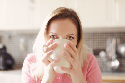 Close-up portrait of a woman drinking coffee