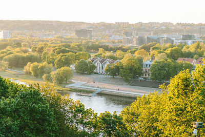 High angle view of river amidst trees and buildings against sky