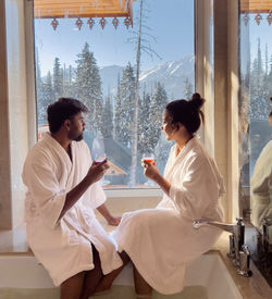 Rear view of couple sitting on table