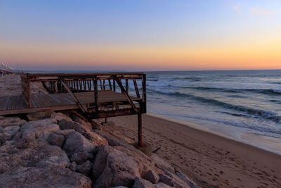 View of calm beach at sunset