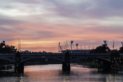 Bridge over river against sky during sunset