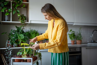 Side view of young woman standing in kitchen