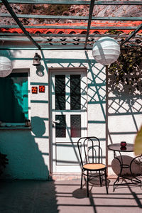 Empty chairs and table by window