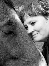 Close-up of woman leaning on horse