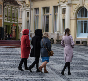 Rear view of women walking on footpath