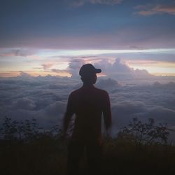 Silhouette man standing on mountain against sky during sunset