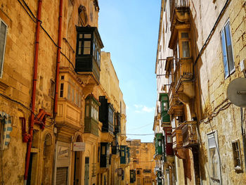 Low angle view of residential old buildings against sky in valletta, malta