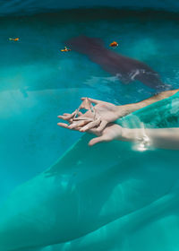 Cropped hands of woman holding prism in swimming pool