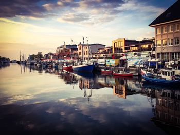 Boats moored at harbor against buildings in city