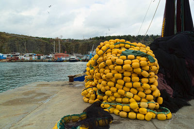 Buoys by fishing nets on pier by river