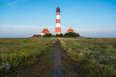 Lighthouse by sea against sky