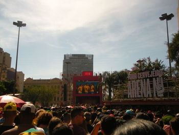 People on street in city against sky