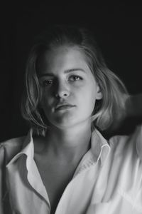 Close-up portrait of a woman over black background