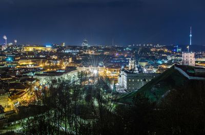 High angle view of city lit up at night