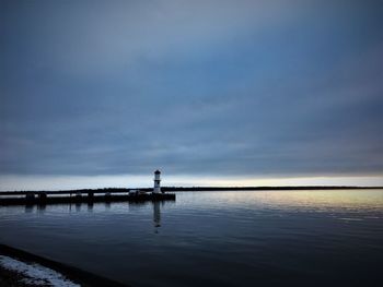 Man standing on pier over sea against sky