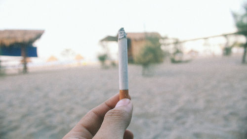 Close-up of hand holding cigarette