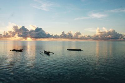 Silhouette boats in sea against sky during sunset