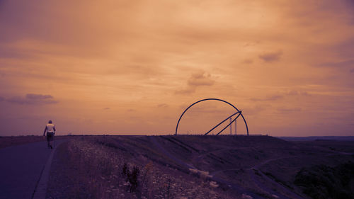 Man on road against sky during sunset