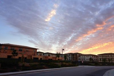 Buildings against cloudy sky at sunset