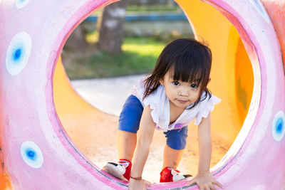 Portrait of girl on play equipment at park