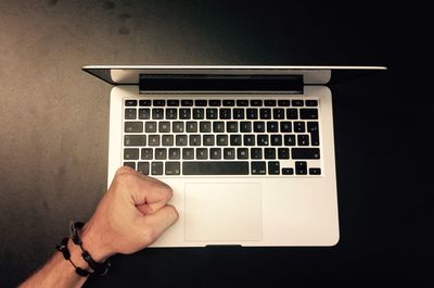 Cropped image of man hand on laptop