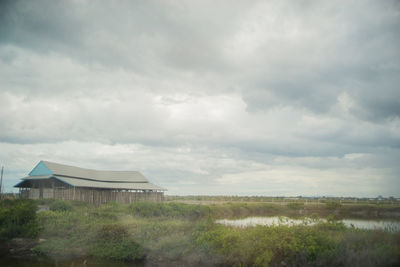 Scenic view of grassy field against cloudy sky