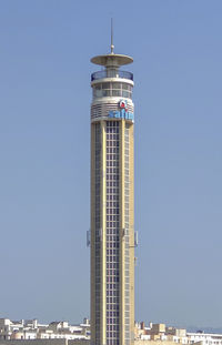 Low angle view of lighthouse by building against clear sky