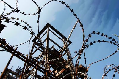 Low angle view of barbed wire against sky