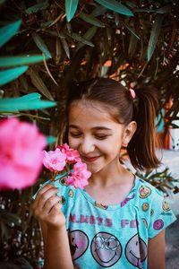 Close-up of girl holding pink flower