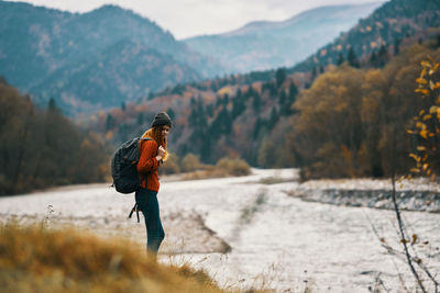 Man standing on land against mountains