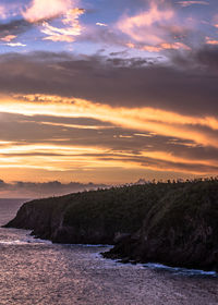 Scenic view of sea against dramatic sky during sunset