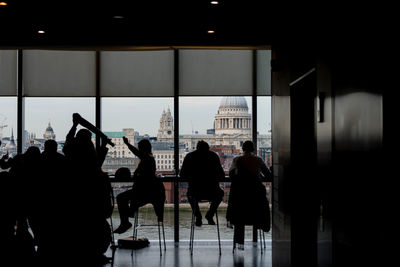 Silhouette people sitting on chair