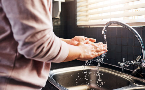 Midsection of man washing hands