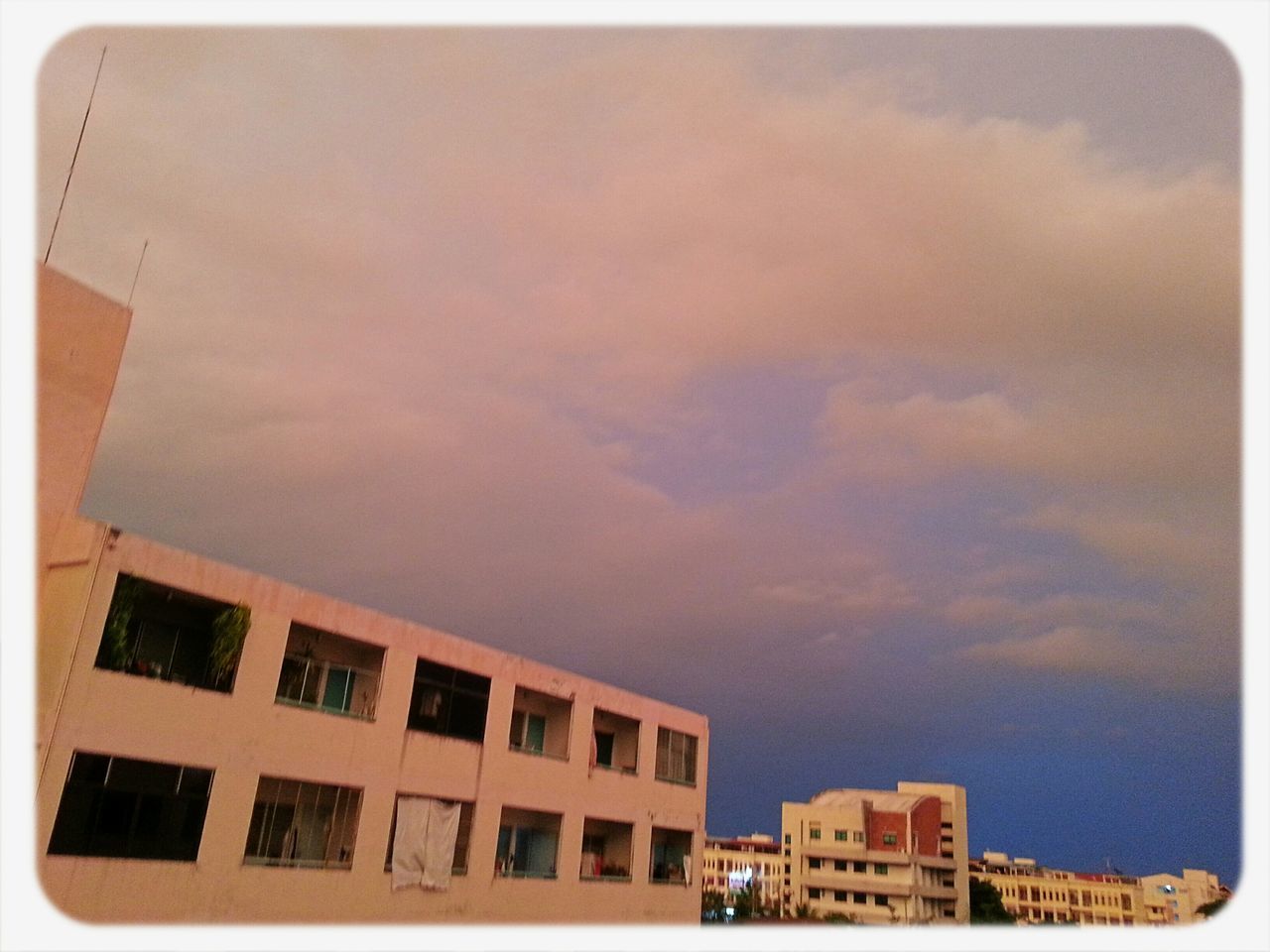 building exterior, architecture, built structure, sky, transfer print, low angle view, auto post production filter, residential structure, cloud - sky, residential building, building, house, city, high section, window, cloud, sunset, outdoors, cloudy, no people