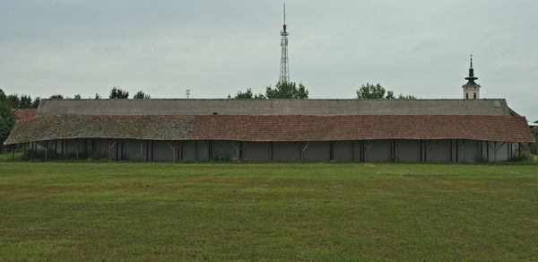 Building on field against sky