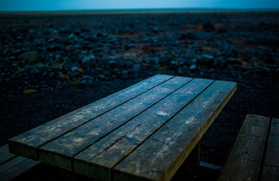 High angle view of wooden bench on shore