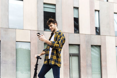 Full length of young man using mobile phone