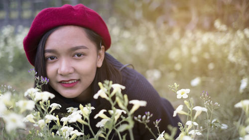 Portrait of smiling woman with red flower