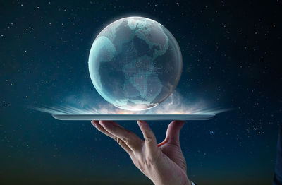 Digital composite image of hand holding carrying planet earth in tray
