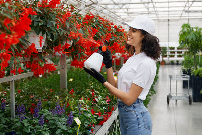 Woman standing by flowering plants