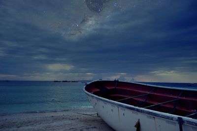 Boat moored on sea against sky during sunset