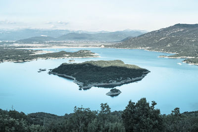 Scenic view of lake by mountains against sky